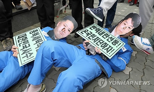 ↑ 퍼포먼스 하는 보수단체 회원들 (서울=연합뉴스) 윤동진 기자 = 대법원 전원합의체가 내란음모·내란선동 혐의 등으로 구속기소된 이석기 전 의원에게 징역 9년 원심을 확정한 가운데 22일 오후 서울 서초역 앞에 모인 보수단체 회원들이 종북세력 척결을 주장하며 이 전 의원과 김정은 노동당 제1비서 얼굴탈을 쓴 사람들을 발로 밟는 퍼포먼스를 하고 있다.