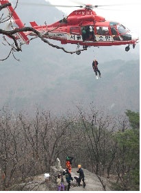 <사진설명 : 지난 4월초 인수봉 의대길 2피치에서 확보물을 설치하지 않고 등반하다가 추락하여 바위 턱에 발목이 골절된 환자를 헬기로 후송하는 모습. >