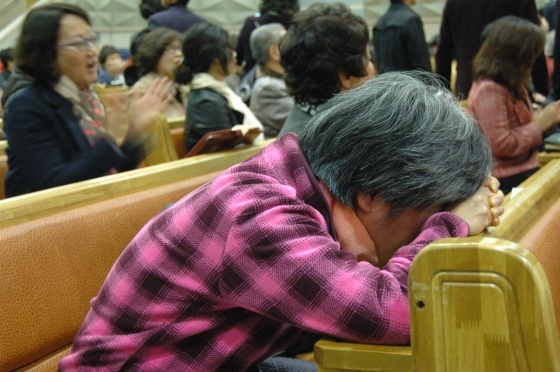 ▲ 한 교인이 교회에서 벌어지는 상황에 엎드려 흐느끼고 있다. (ⓒ장동민 기자)