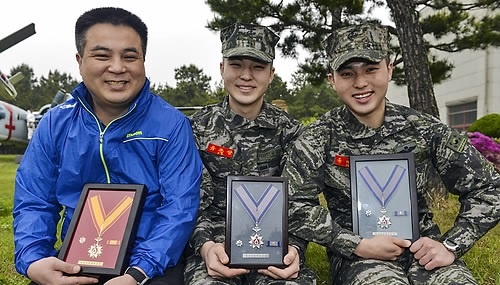 ↑ 해병대 삼부자의 헌혈 나눔  예비역 해병인 유승국씨(46.왼쪽)와 두 아들 재상(22.오른쪽)과 준상(20) 해병이 적십자헌혈유공장 금장과 은장을 들고 기념촬영하고 있다. 유승국씨는 해병대 입대 후 30년 동안 헌혈에 동참해 2013년 적십자 헌혈 유공장 금장을 수상했다. 유씨의 두 아들들 또한 헌혈로 2014년 5월과 10월에 적십자헌혈유공증 은장을 수상했다. 이들 해병대 삼부자 가족은 지난해 8월 가족이 함께 모은 헌혈증 100장을 백혈병 환자들을 위해 대한적식자사 강원지사에 기증하기도 했다. 2015.5.5 << 해병대 제공 >> 