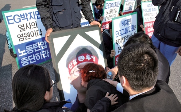 5월12일 포스코 광양제철소 앞에서 고 양우권씨의 영정 사진을 붙잡고 아내 하아무개씨가 울부짖고 있다.