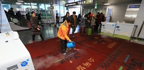 전북 김제에서 구제역이 발생해 방역당국이 긴급 살처분과 방제활동에 돌입한 가운데 13일 오후 제주공항에 도착한 항공기 승객들이 방역설비를 통과하고 있다. 