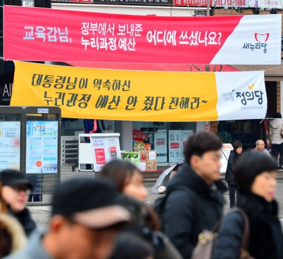 28일 경기도 성남 미금역사거리에 누리과정예산 논란과 관련된 새누리당과 정의당의 주장이 담긴 현수막이 나란히 내걸려 있다