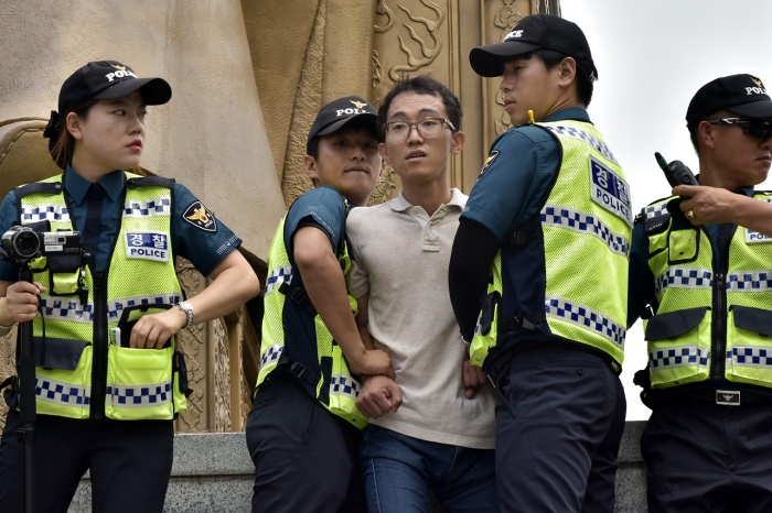 알바노조 소속 조합원들이 12일 오전 서울 세종로 광화문광장에 있는 세종대왕 동상에 올라가 최저 임금 1만원 인상을 요구하는 기습시위를 벌이고 있다.