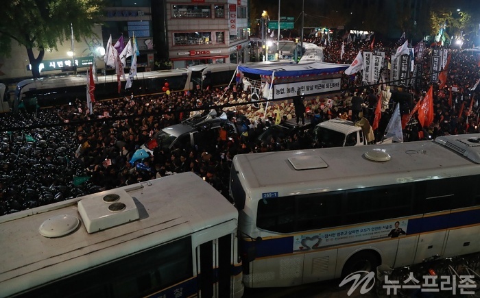 ▲ 13일 새벽 서울 광화문 주변 곳곳에서 내자동으로 행진해 온 시민들이 경찰과 대치하는 가운데 한 참가자가 경찰버스 위에 올라 경찰과 몸싸움을 벌이고 있다. 