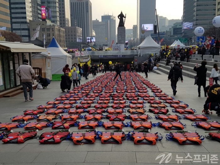 ▲ 서울 광화문광장에 정렬된 구명조끼를 시민들이 살피고 있다. 이 구명조끼들은 공연예술단체 '창작그룹노니'가 세월호 참사 희생자 304명을 잊지 말자는 취지로 마련했다.(사진= 안데레사기자)