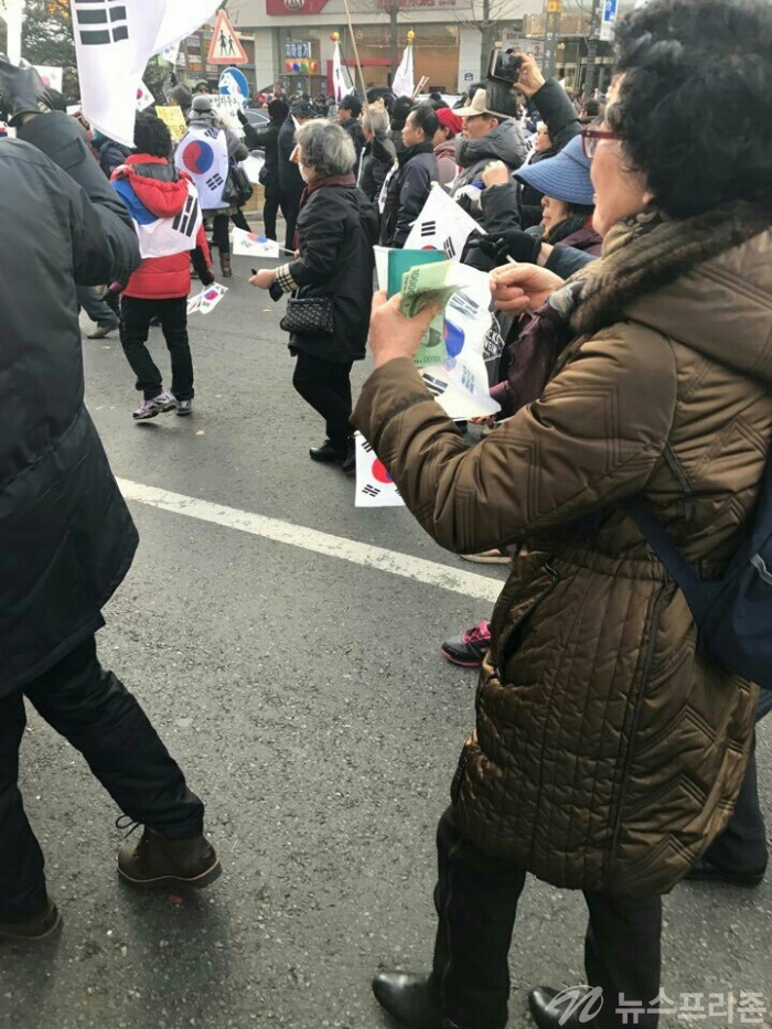 ▲ 보수단체의 어느 회원은 알수 없는 봉투를 끄내며 돈을 헤아리고 있다( 사진= 김현태기자) 