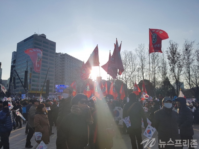 서울시청 방향 도로에 헌재의 탄핵 기각을 촉구하는 펼침막을 든 시민들이 서 있다.