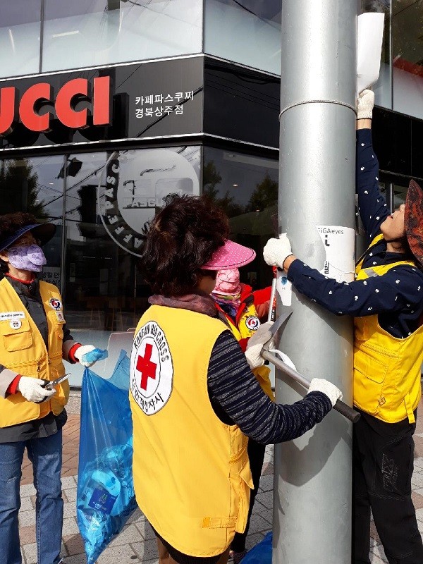 29일 상주시 북문동 적십자봉사회 회원들이 불법광고물을 뜯어내고 있다./ⓒ상주시