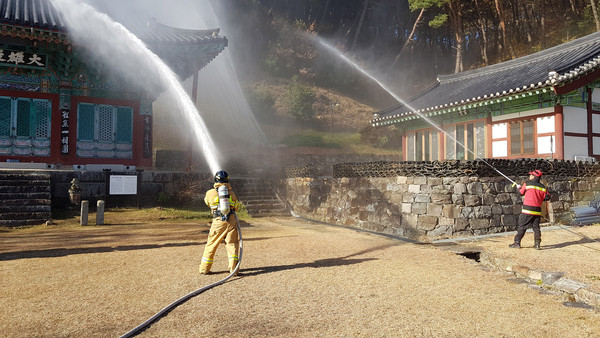 산청군과 소방서는 지난 21일 율곡사 대웅전(보물 제374호)에서 목조문화재 화재와 산불 발생 상황을 가정해 소방훈련을 진행했다./ⓒ산청군