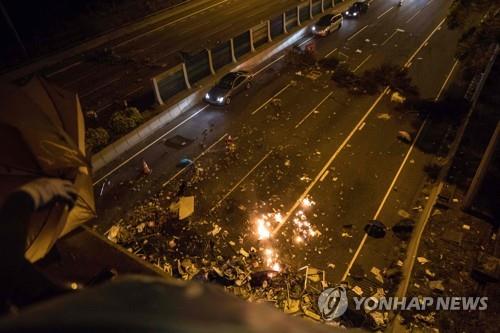 교통을 방해하기 위해 도로에 화염병 등을 던진 시위대