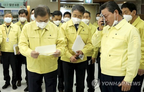 문재인 대통령이 25일 대구광역시 남구청에서 코로나19 확산에 따른 취약계층 복지전달체계 현황 보고를 받은 뒤 조재구 남구청장(오른쪽)으로부터 받은 건의 편지를 읽고 있다. 조 청장은 편지를 전달하며 손수건으로 눈물을 닦고 있다. 2020.2.25