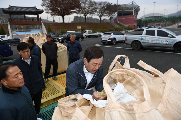 황선봉 예산군수가 공공비축미 매입현장에서 출하농가를 격려하며 벼 품위를 살펴보고있다