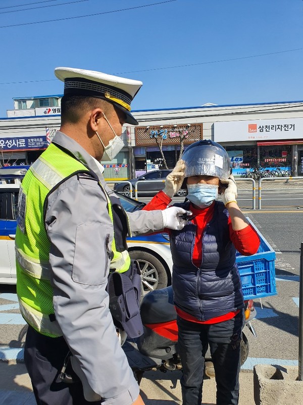 경찰관이 안전모 배부활동을 통해 교통사고예방에 힘쓰고 있다.Ⓒ보령경찰서