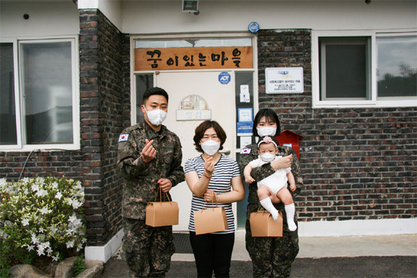 육군 6군단 정보통신단 홍재화 중위(28세)와 해군 서은선 중위 부부가 포천지역 아동복지시설인 '꿈이 있는 마을'에 위문품을 전달하고 생할지도사와 함께 기념촬영을 하고 있다.(사진=포천시청)