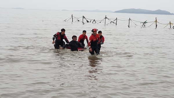 보령해경이 갯벌에서 조개채취를 하다 고립된 부녀를 구조해 육지로 이동하고 있다.©보령해양경찰서