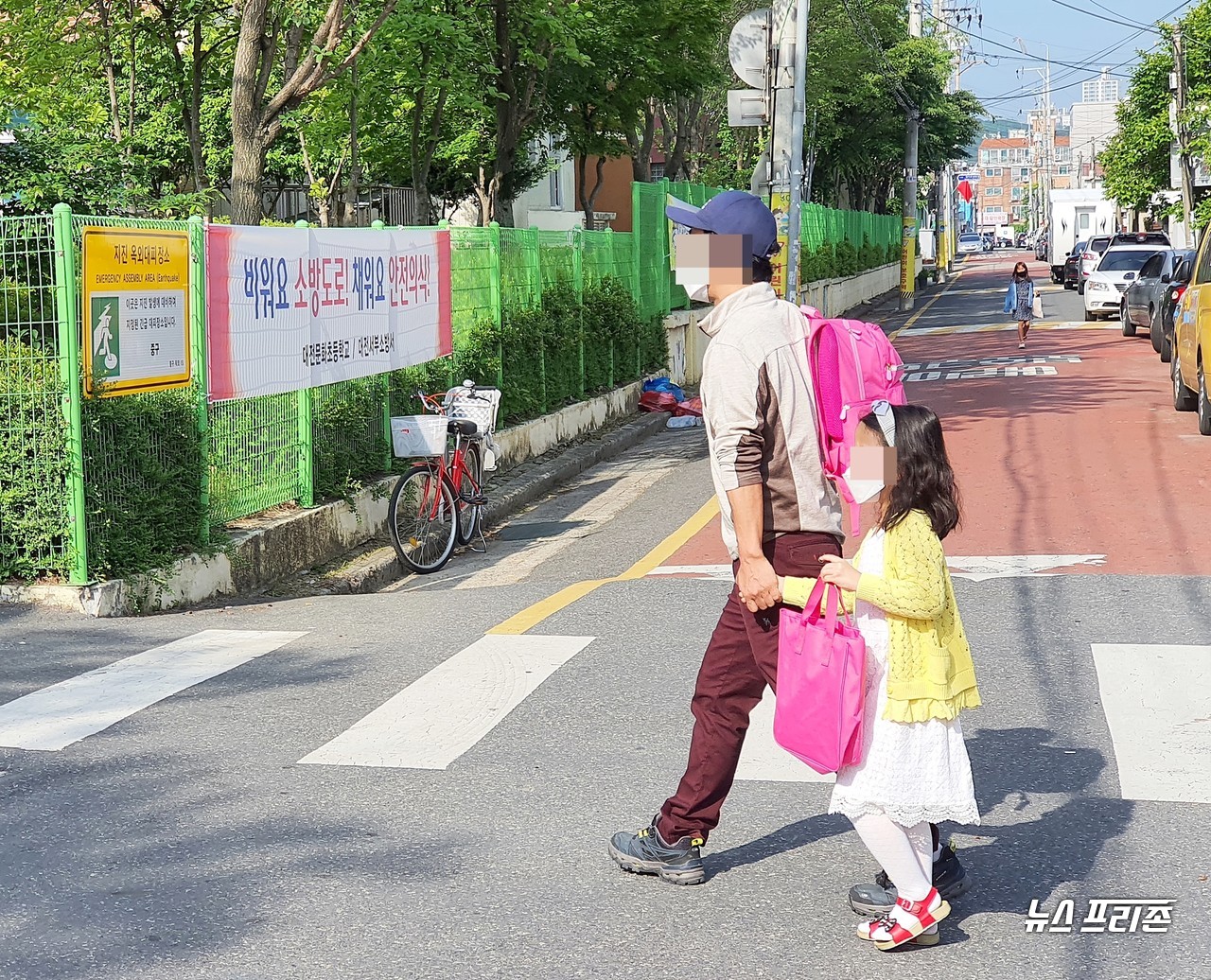 대전문화초등학교 앞 스쿨존에서 27일 오전 초등학생이 아빠의 손을 잡고 함께 횡단보도를 건너고 있다./ⓒ이현식 기자