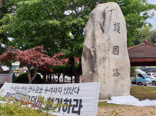 포천시와 의정부시 경계에 있는 축석고개 인근에 설치된 43번국도 호국로 표지석. 진보시민단체가 설치한 표지석 철거 요구 현수막이 눈에 띈다. (사진=이건구기자)