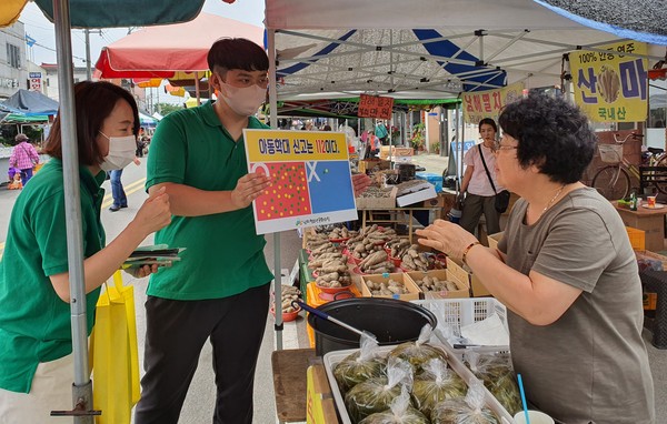 지난 17일 남지전통시장에서 남지청소년문화의집 직원이 아동학대 예방 캠페인을 진행모습./ⓒ창녕군