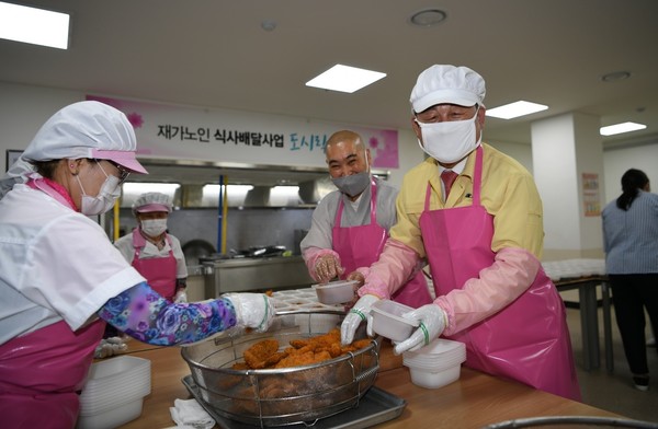 황선봉 군수(오른쪽)가 노인종합복지관에서 저소득층 어르신들에게 전할 도시락을 포장하고 있다./ⓒ예산군청