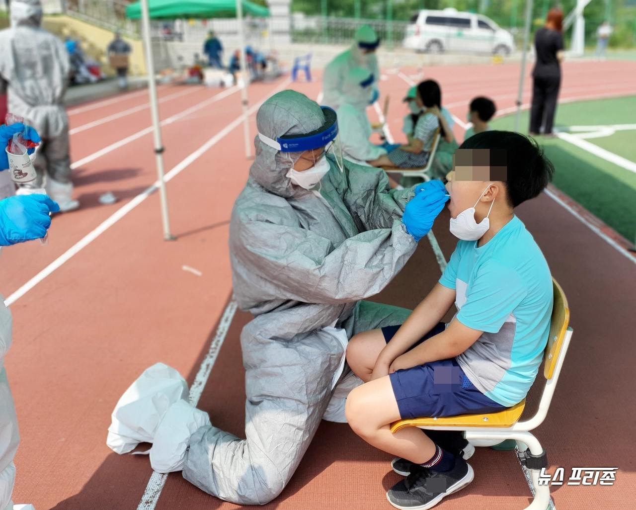 대전에서 신종 코로나바이러스 감염증(코로나19) 학생 확진자가 4명이나 나와 교육당국이 바짝 긴장한 가운데, 대전천동초등학교 5학년 학생들을 대상으로 1일 실시한 전수검사 결과, 2일 오전 모두 음성으로 판정됐다. 하지만 2일 오전 11시쯤 대전시는 2명(123번, 124번)의 확진자가 추가로 발생했다고 안전 안내 문자를 통해 시민들에게 알렸다. 사진은 대전천동초등학교에서 의료진이 무릅을 굽힌채 학생의 코로나19 검사를 위해 애쓰고 있는 모습./ⓒ이현식 기자