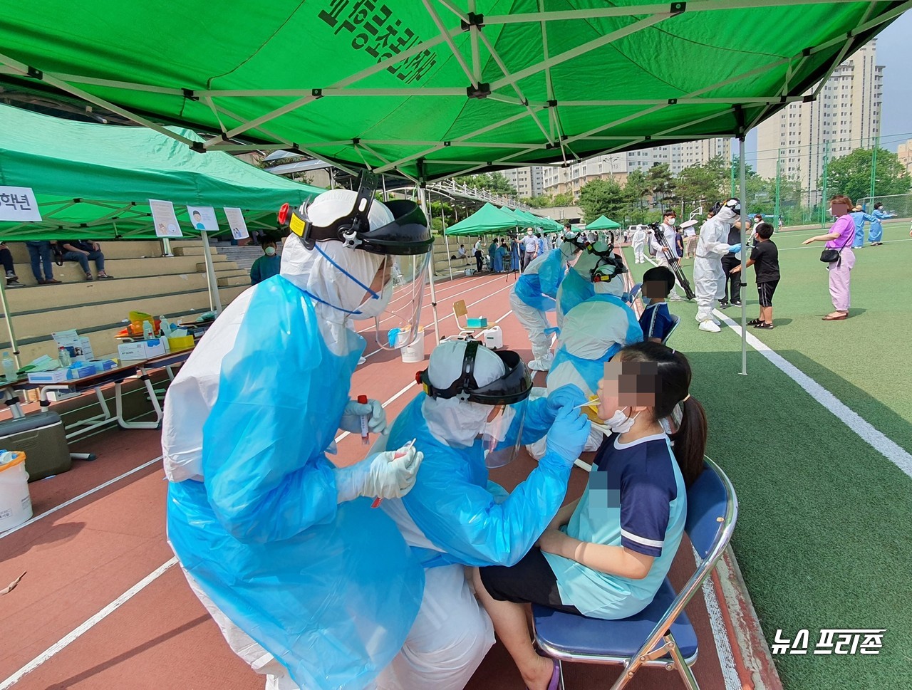 대전 낮기온이 30도까지 수은주가 오르며 더운 날씨를 보이는 2일, 대전천동초등학교에서 전학년 대상, 코로나19 전수검사를 하는 가운데, 보건당국 의료진들이 어린 학생들을 살피며 땀방울을 흘리고 있다./ⓒ이현식 기자