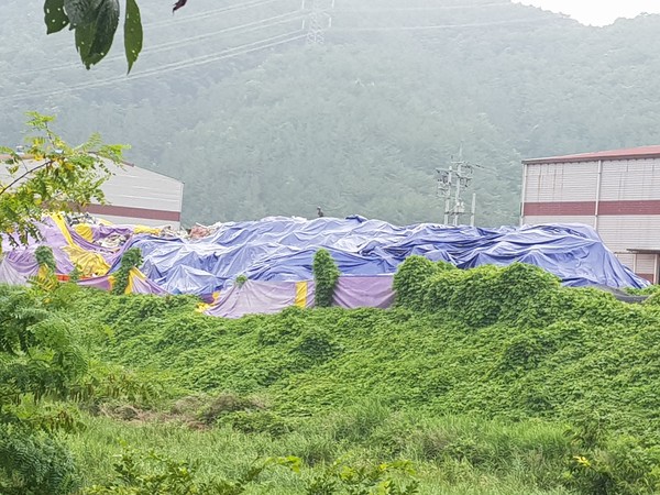 사천시는 장마철에 대비해 고성군 경계지역에 위치한 폐기물처리업체 불법 폐기물(5,000톤)에 방치 폐기물 덮개를 설치토록 고성군에 이행요청했다./ⓒ사천시