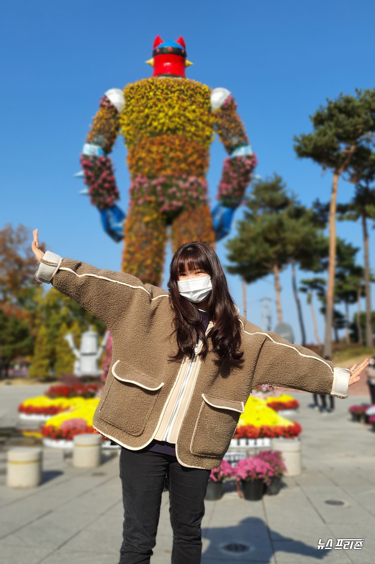 대전 유성 국화전시회가 유림공원 및 온천공원 일대에서 꽃이 형형색색 수를 놓고 있는 가운데, 30일 오후 노은동에서 온 서한솔씨(여)가 국화로 만든 로보트태권V 조형물을 배경으로 포즈를 하며 추억의 인생사진을 찍고 있다./ⓒ이현식 기자