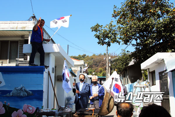 바르게살기구리시협의회 오형근 회장이 인창동 태극기 벽화마을 사업 중 태극기 달기를 직접 선보이고 있다(사진 좌측) 아래로 이번 사업에 적극 힘을 보탠 인창렬 도의원과 인창통장이 태극기 달기에 참여하고 있다./Ⓒ이건구기자