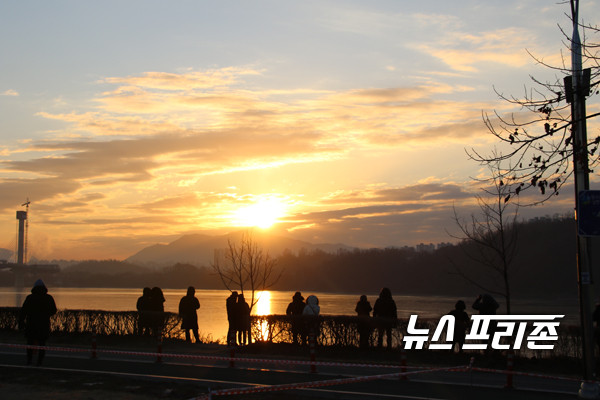 구리 한강시민공원과 꽁꽁 언 한강을 환히 비추며 떠로르고 있는 신축년 첫 태양을  바라보며 가족의 건강과 무사안일을 기원하고 있는 시민들./Ⓒ이건구기자