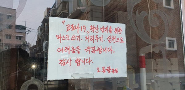 골목길을 따라 나타난 동네 목욕탕이 우뚝 서있다. 코로나19 때문에 사람이 없어 힘이 들텐데도. 오히려 함께 극복해내자는 문구가 새롭다./ⓒ김경훈 기자