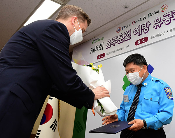 오비맥주 배하준 대표(왼쪽)가 29일 도로교통공단 서울특별시지부에서 열린 ‘음주운전 예방 유공자 시상식’에서 유공자로 선정된 모범 운전자에게 축하 꽃다발을 전달하고 있다. / ⓒ오비맥주