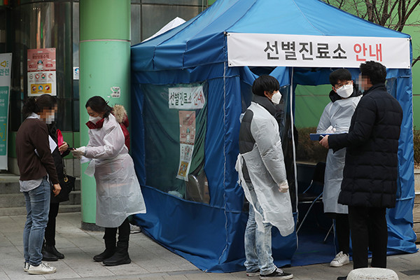 7일 서울 중구보건소 신종 코로나바이러스 감염증 선별진료안내소를 찾은 시민들이 보건소 관계자들과 대화를 하고 있다. 중앙사고수습본부는 이날 “신종코로나 검사는 선별진료소가 설치된 보건소와 의료기관에서 가능하다”고 발표했다. 검체 채취가 가능한 의료기관 명단은 신종코로나 누리집의 ‘가까운 선별진료소 찾기’에서 확인할 수 있다. 신속 진단 검사 도입에 따라 결과는 6시간 안에 나온다.&nbsp;