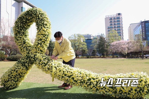 도성훈 인천시교육감이 교육청 중앙잔디광장에 설치된 추모 리본을 상징하는 대형 토피어리에 추모 리본을 묶고 있다. / ⓒ인천시교육청