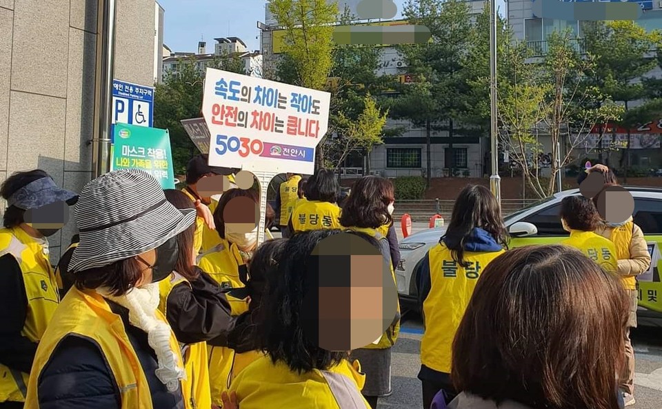 [천안=뉴스프리존]충남 천안시 불당동행정복지센터 사거리에서 안전속도 5030 캠페인에 동참한 한 시민이 '속도의 차이는 작아도 안전의 차이는 큽니다 5030 천안시'라고 기재된 푯말을 들어보이고 있다./ⓒ김형태 기자