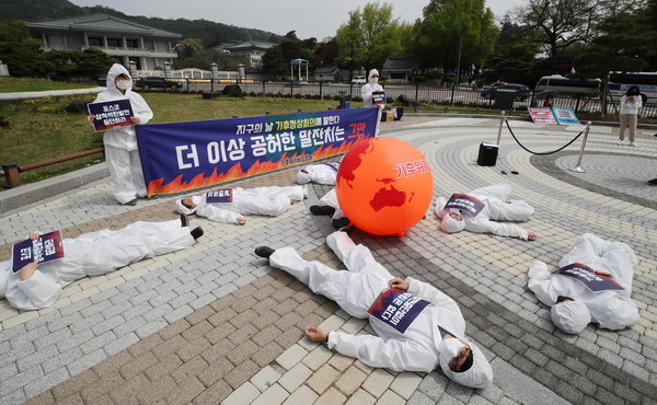 지구의날 청와대 앞 기후위기 퍼포먼스= 지구의날인 4월 22일 오전 기후위기비상행동이 청와대 분수대 앞에서 뜨거워진 지구에 고통받는 인간을 표현한 퍼포먼스를 하고 있다.