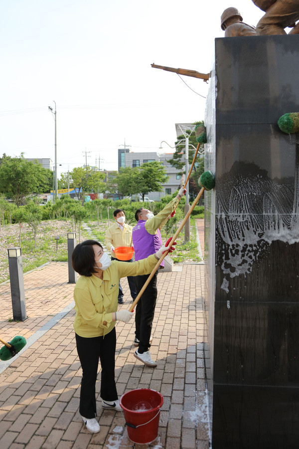 서산시의회 이연희 의장과 의원들이 독립유공자탑 등의 비석에 끼인 물때를 닦아내고 있다./ⓒ서산시의회