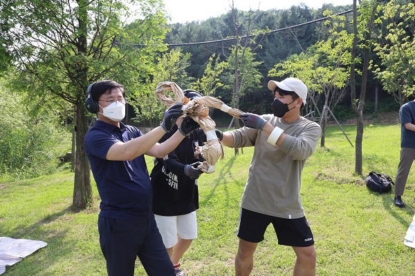 한대희 시장(왼쪽)이 헤드폰을 끼고 청년들과 함께 ‘사일런트 아트 워킹 투어’를 하면서 종이인형을 만들고 있다./ⓒ군포시