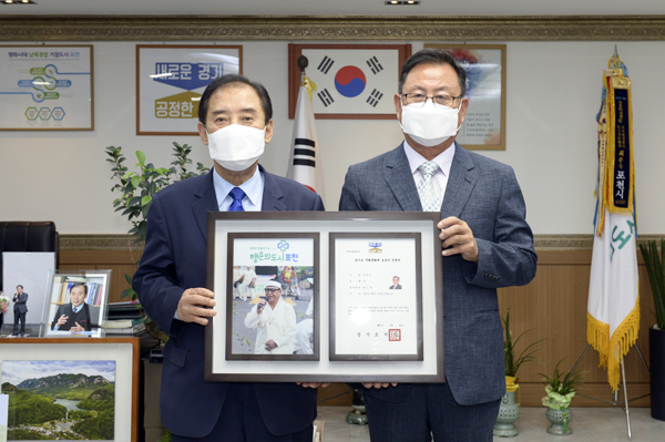 박윤국 포천시장이 ‘경기도 무형문화재 제35호 포천메나리’ 보유자로 인정된 김영오 보유자에게 무형문화재 보유자 인정서를 전수하고 기념촬영을 하고 있다./Ⓒ포천시청