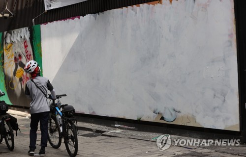 3일 오전 윤석열 전 검찰총장 아내 김건희 씨를 비방하는 벽화로 논란이 일었던 서울 종로구 관철동의 한 중고서점 외벽의 벽화가 흰 색으로 덧칠돼 있다.     흰 페인트로 칠해진 벽화는 '쥴리의 남자들' 등의 문구가 적힌 그림과 여성의 얼굴 옆에 '쥴리의 꿈! 영부인의 꿈!'이 쓰였던 그림이다. 문제가 되지 않은 나머지 벽화 4점은 그대로 남아 있다. 2021.8.3