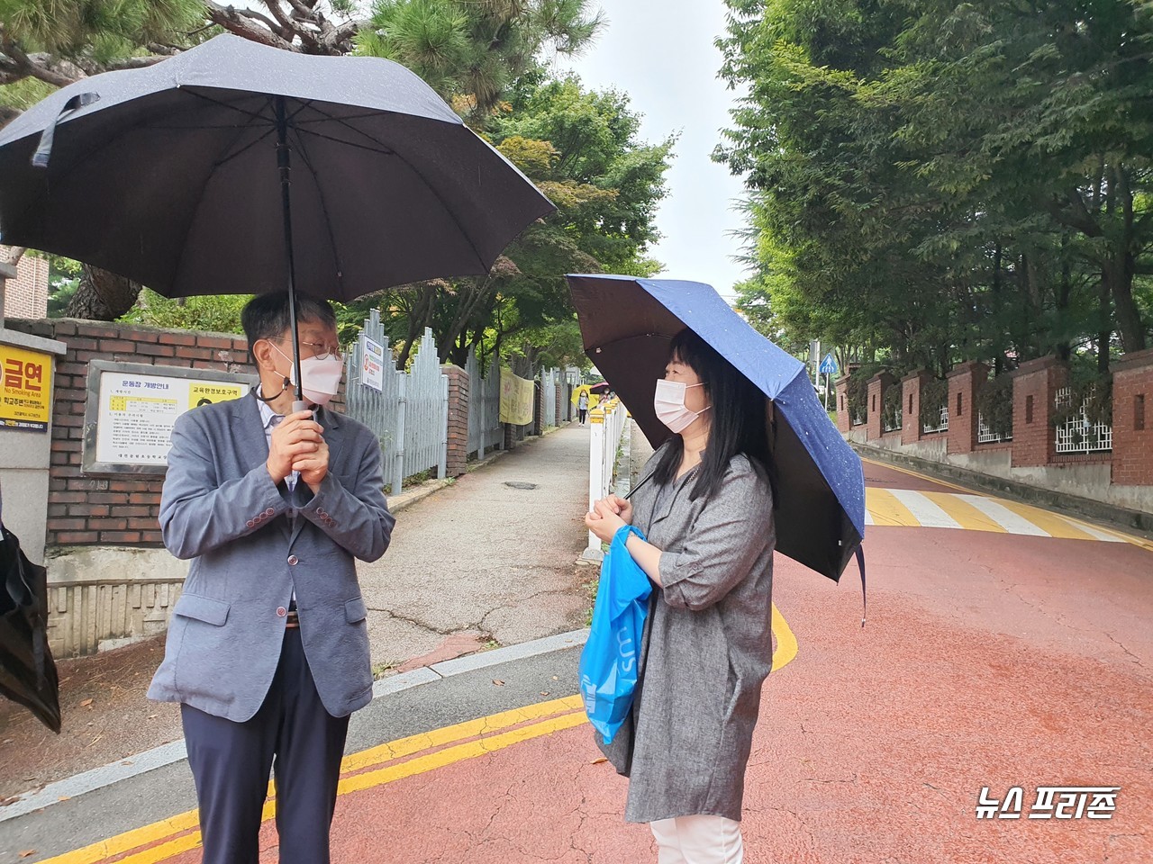 대전시교육청 오석진 교육국장(왼쪽)이 31일 오전 '2학기 등교 상황 점검'과 '학교 현장의 목소리'를 청취하기 위해 대전둔원초등학교를 방문한 가운데 학교 정문 앞에서 학부모와 웃으며 이야기를 나누고 있다./ⓒ이현식 기자