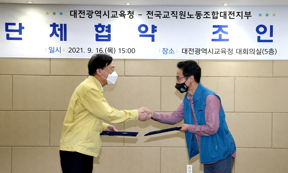 설동호 대전시교육감(왼쪽)과 전국교직원노동조합대전지부 신정섭 지부장이 대전시교육청과 전교조대전지부와의 단체협약을 체결한 후 악수를 하고 있다./ⓒ대전시교육청