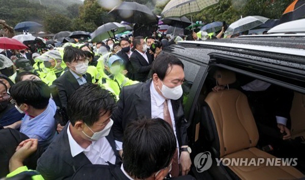 우리공화당 측 반대자들은 박정희 생가를 찾은 윤석열 전 총장의 진입을 막아섰다. 윤석열 전 총장은 이들 반대 무리를 뚫고 박정희 추모관에 진입해 추모를 끝낸 뒤, 경찰의 호위를 받으며 겨우 빠져나갔다. 그가 참배하는 데 걸린 시간은 2~3분에 불과했다. 사진=연합뉴스