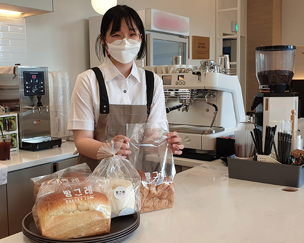 빵그레 광주점 자활근로 청년 직원이 빵을 포장하고 있다. /ⓒ하이트진로