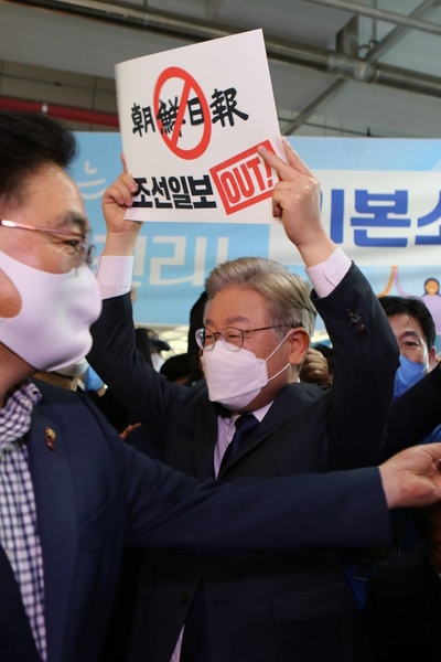 2일 더불어민주당의 부산울산경남 지역경선에서도 과반 득표에 성공한 이재명 경기지사가 연설회장에 들어가기 전 한 지지자가 건네준 '조선일보 OUT' 손팻말을 번쩍 들어보이고 있다. 뉴스프리존