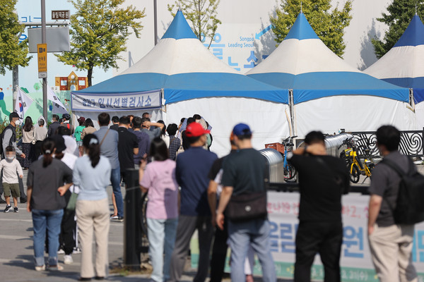 서울 송파구 올림픽공원 앞에 설치된 임시선별검사소에서 시민들이 코로나19 검사를 받기 위해 줄을 서있다.