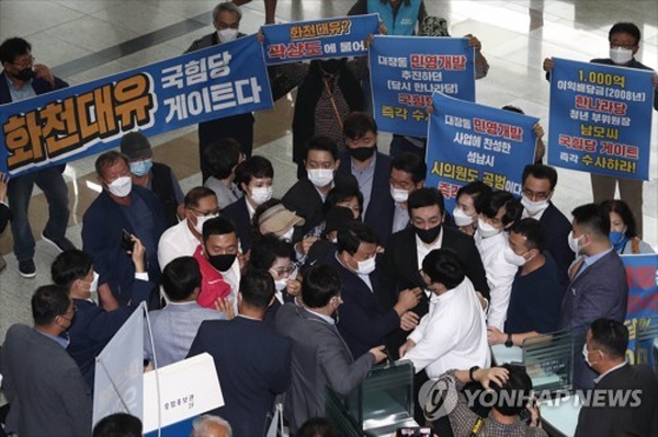 국민의힘 의원들 및 관계자들이 지난달 27일 성남시청을 방문해 시청안으로 들어가던 도중 성남시 관계자들이 입장을 제지하는 모습. 뒤에는 국민의힘 의원들에 항의하며 대장동 건은 '국민의힘 게이트'라고 피켓시위하는 시민들의 모습도 보인다. 사진=연합뉴스