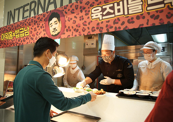 유튜버 밥굽남이 아워홈이 운영하는 여의도 소재 구내식당에서 열린 '플렉스 테이블' 이벤트에서 '돈마호크카츠'를 배식하고 있다. /ⓒ아워홈