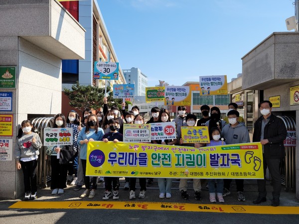 대명6동 우리마을교육나눔 추진위원회와 청소년 기획단 ‘티키타카’ 단원들이 어린이 교통사고예방을 위해  '노란발자국'을 설치했다./ 남구청