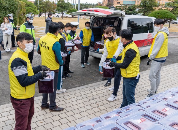 광양제철소 직원들이 사회복지시설과 주변 이웃들에게 '사랑의 김장김치'를 전달하기 위해 김치를 나르고 있다.